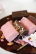 pink and brown chocolate bar on brown wooden round plate