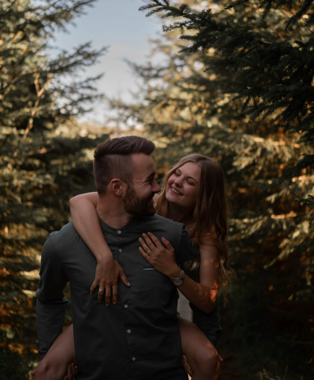 man in black crew neck t-shirt hugging woman in black sleeveless dress