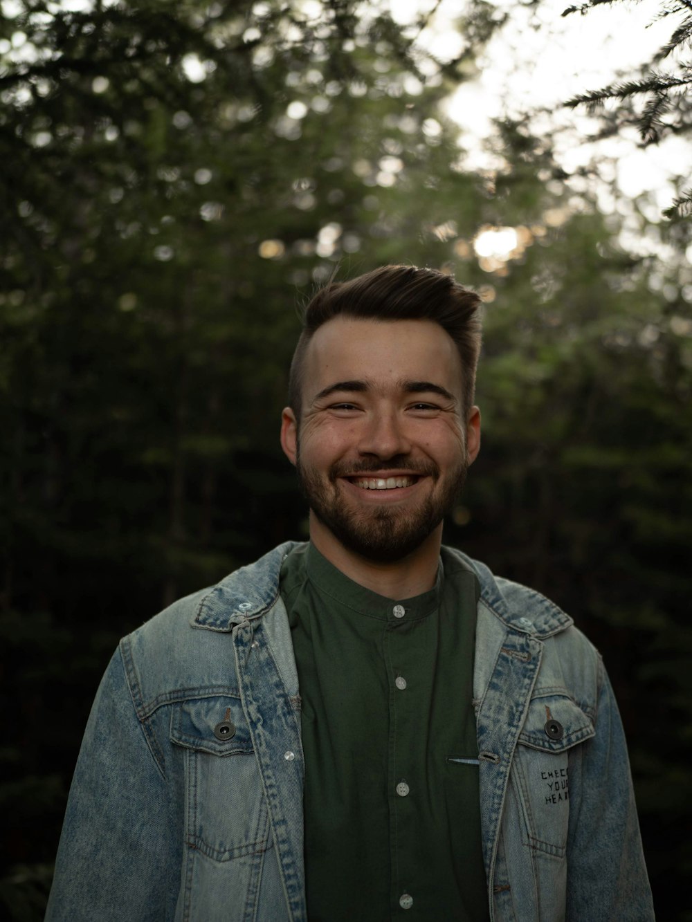 man in blue denim jacket smiling