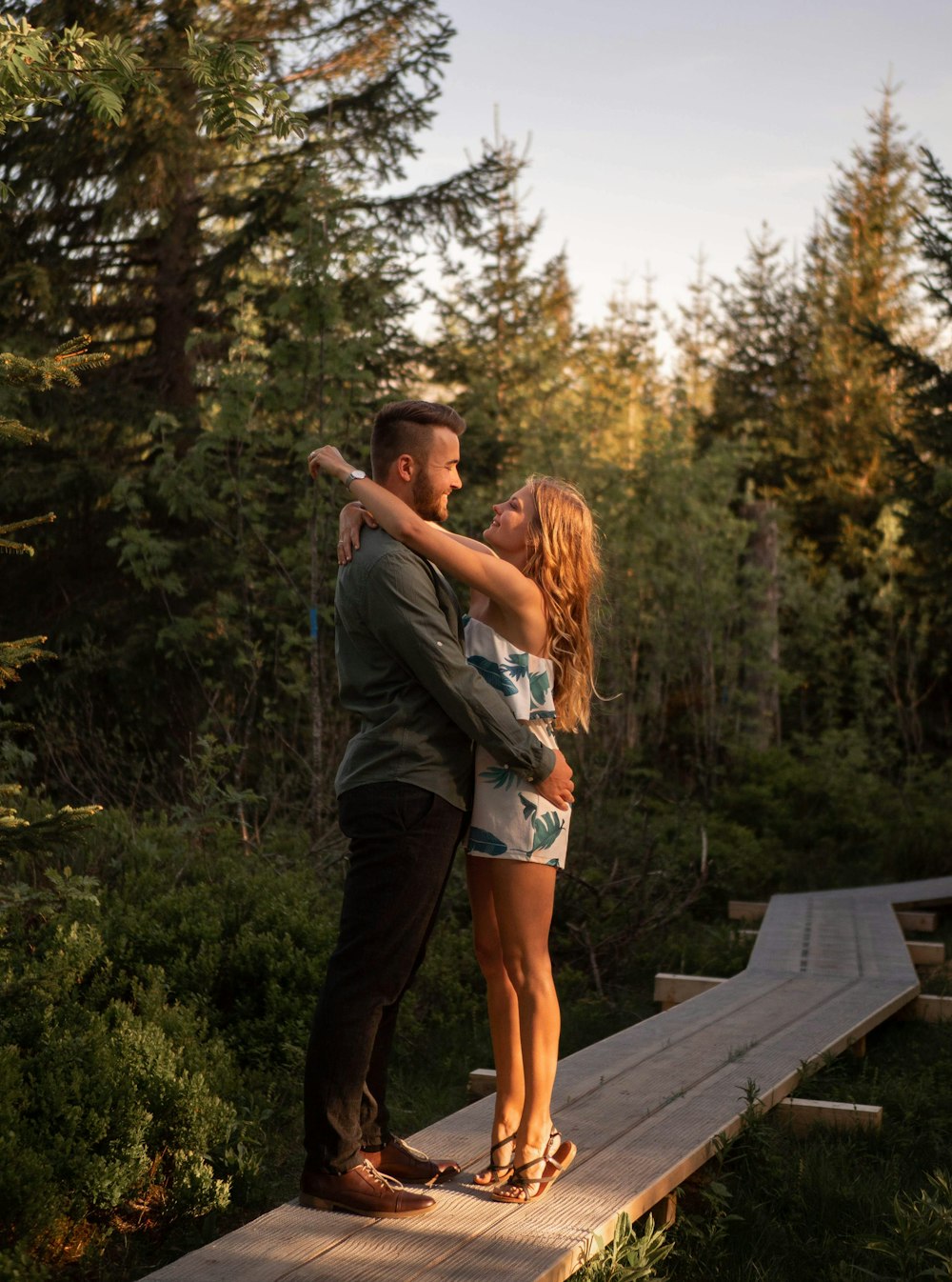 woman in gray long sleeve shirt and brown shorts standing on brown wooden dock during daytime