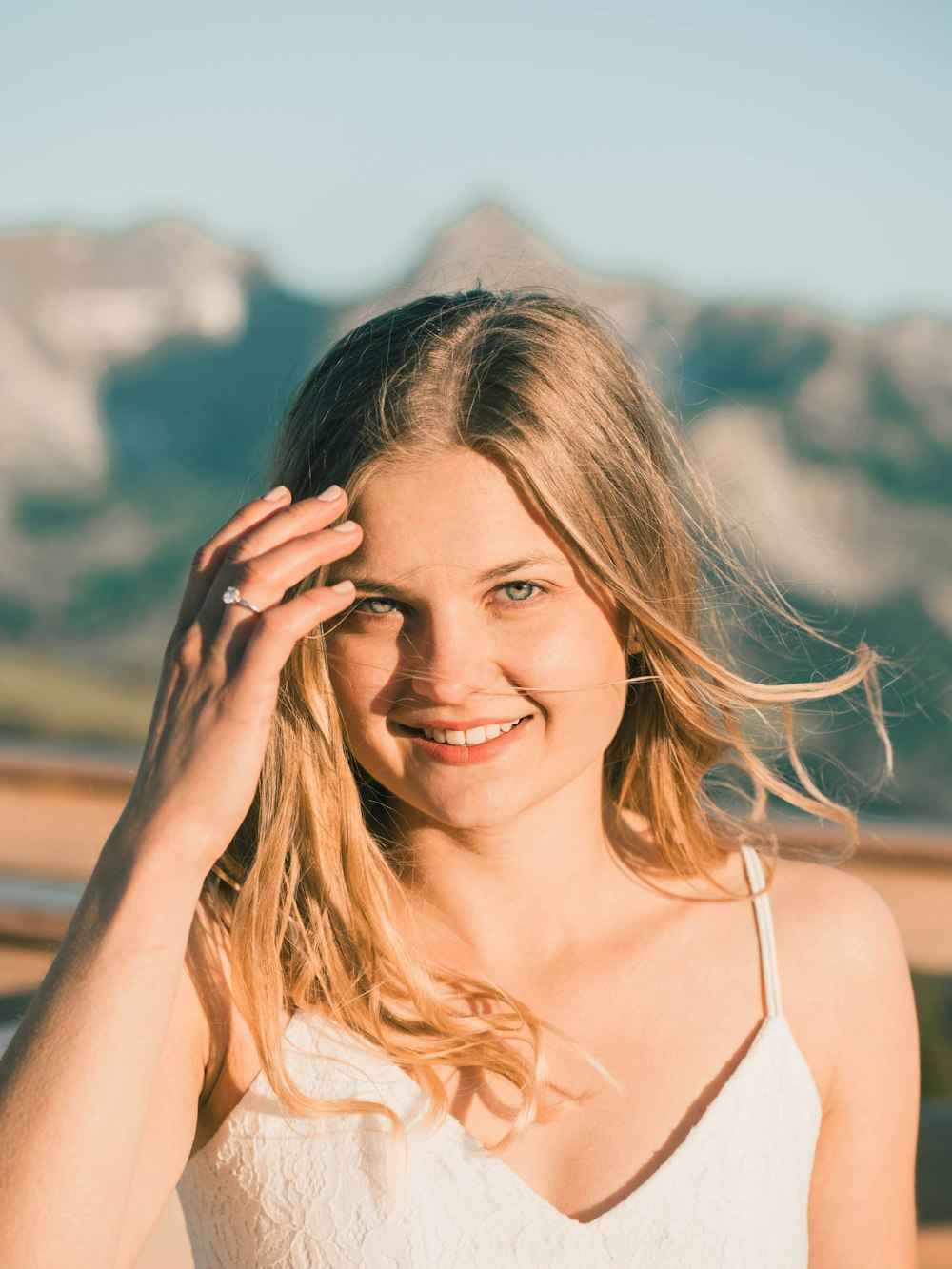 a woman in a white top is smiling for the camera