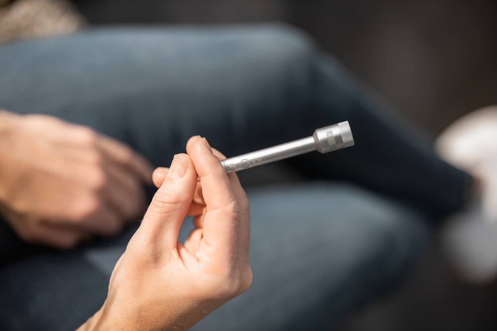 person holding silver and black pen