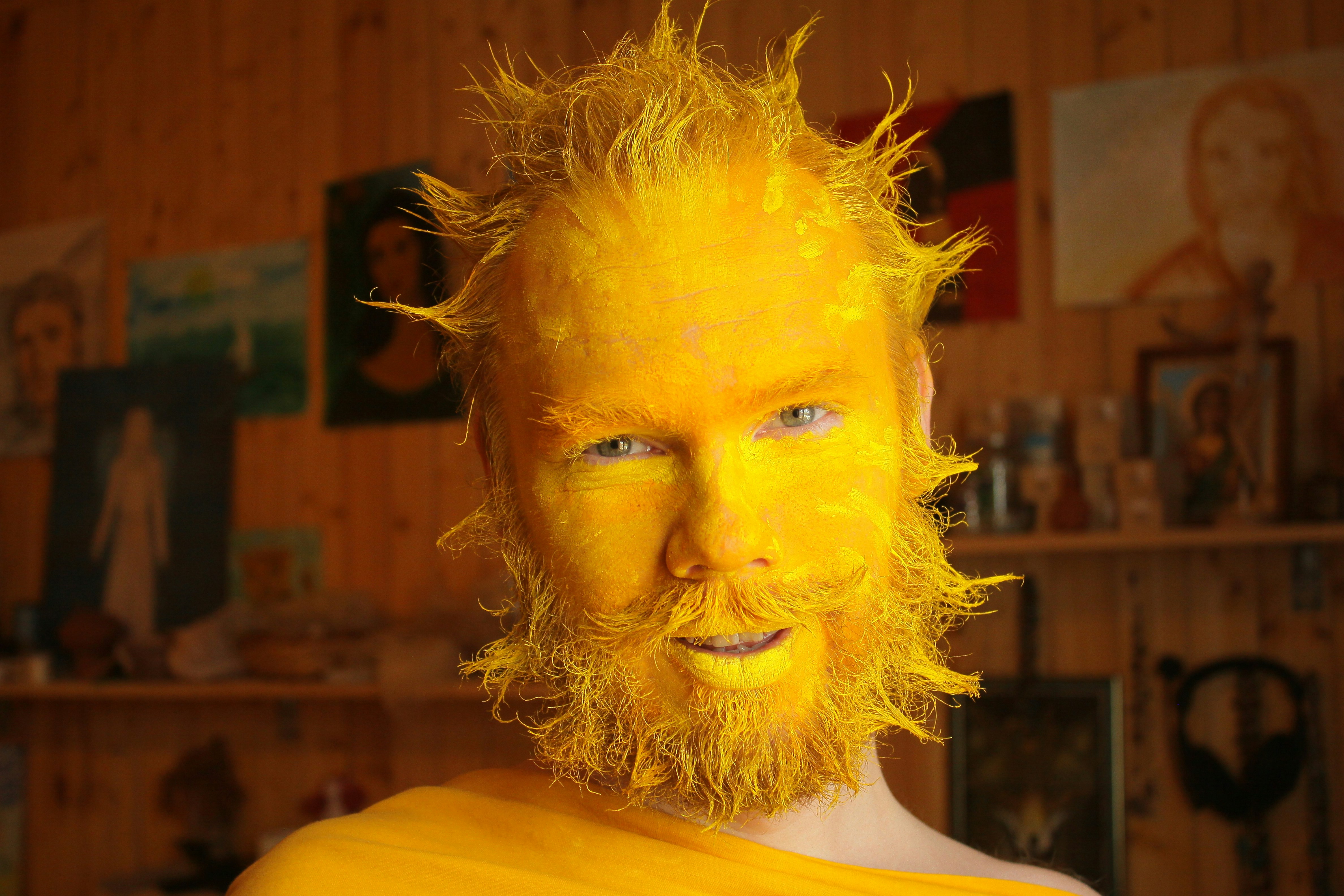 Carnival image of the sun. The man's face is painted bright yellow, and his hair and beard are laid in rays. • Карнавальный образ солнца. Лицо мужчины выкрашено в яркий желтый цвет, а волосы и борода уложены лучиками.
