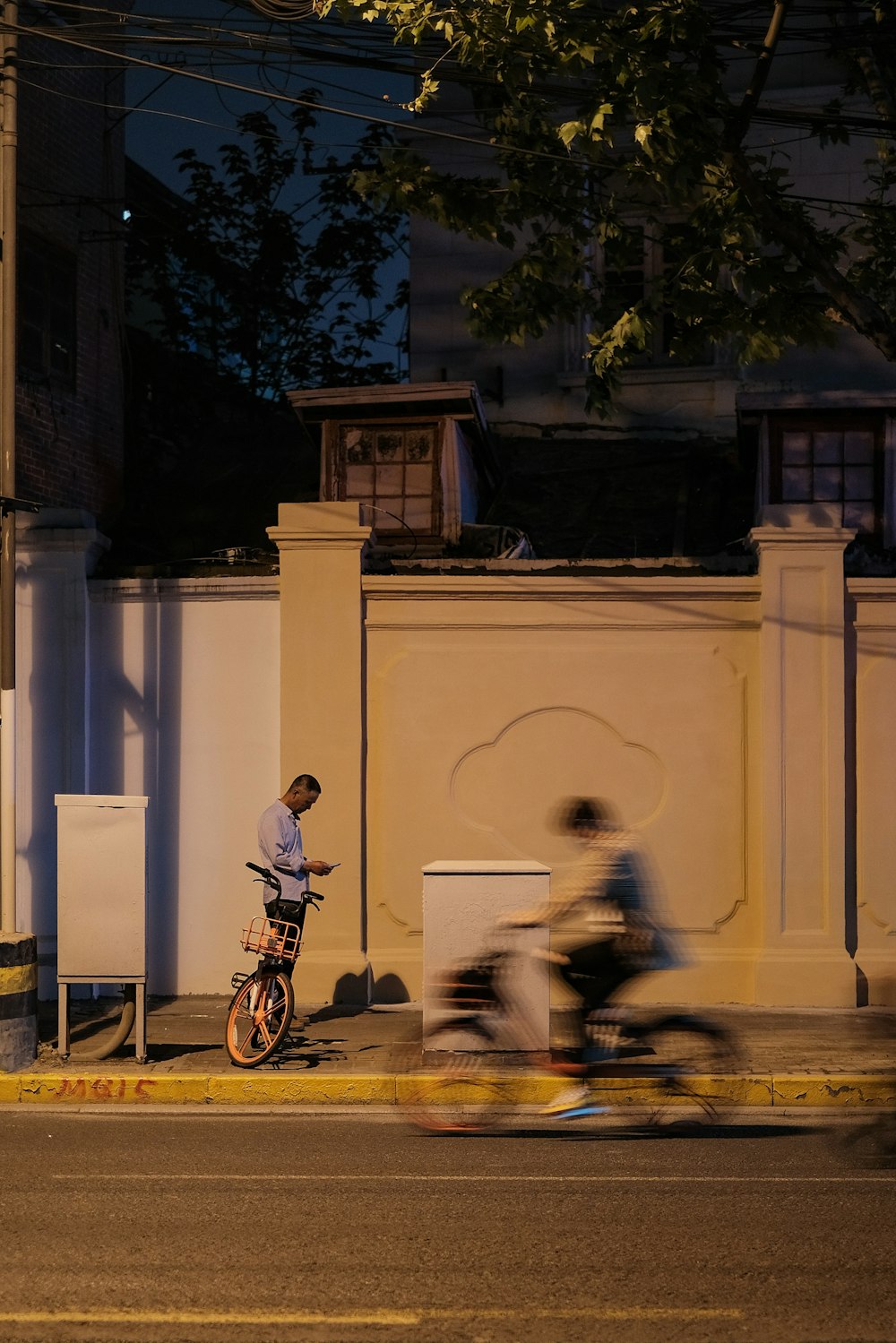 man in black jacket riding bicycle near white concrete building during daytime