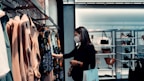 woman in black long sleeve shirt standing in front of clothes