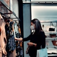 woman in black long sleeve shirt standing in front of clothes