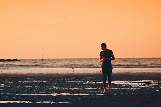 man in black shirt and black pants standing on beach during sunset in Dunkerque France