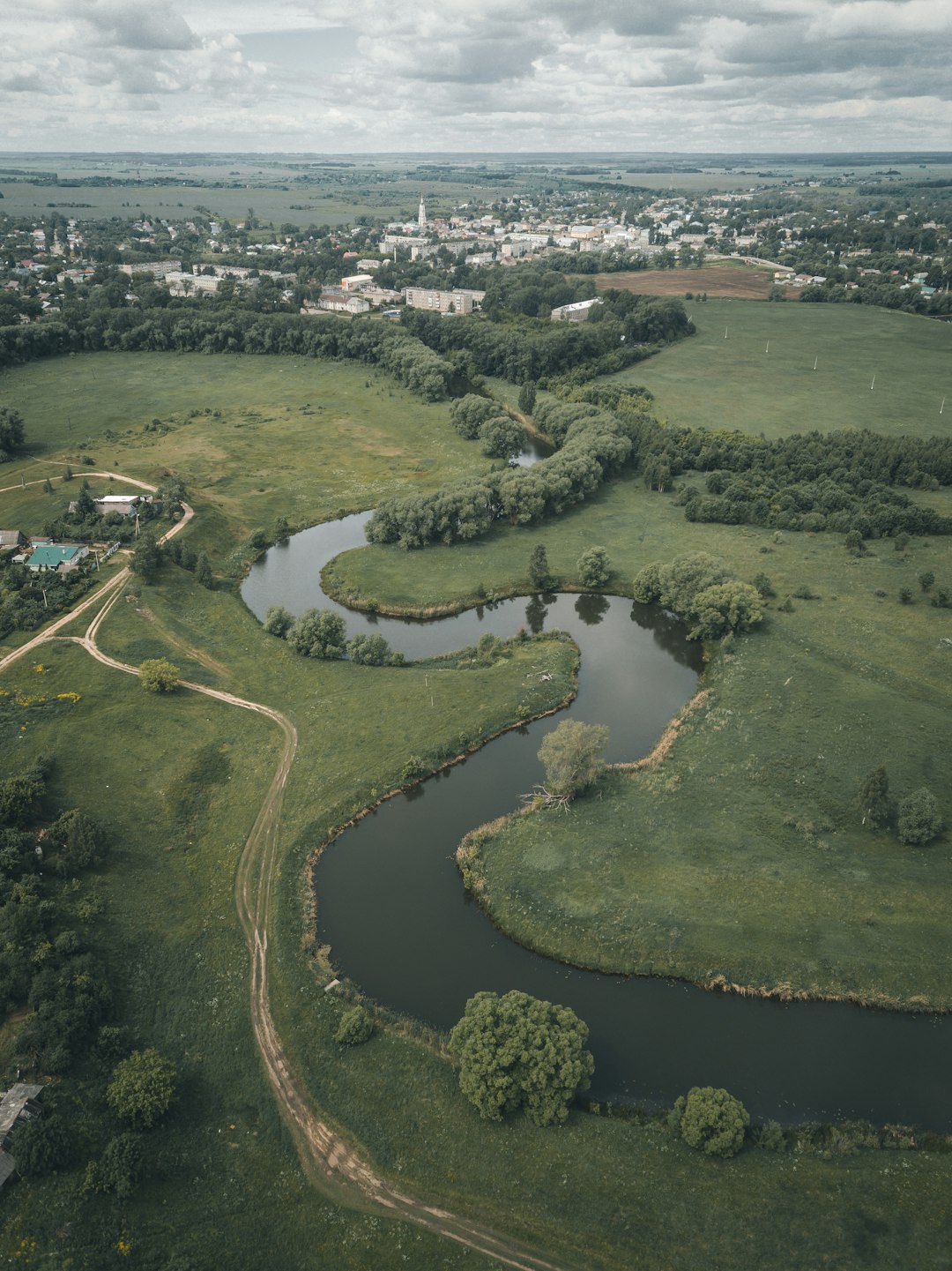 aerial view of green grass field and river