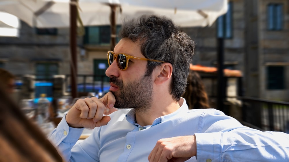 hombre con camisa de vestir blanca con gafas de sol negras