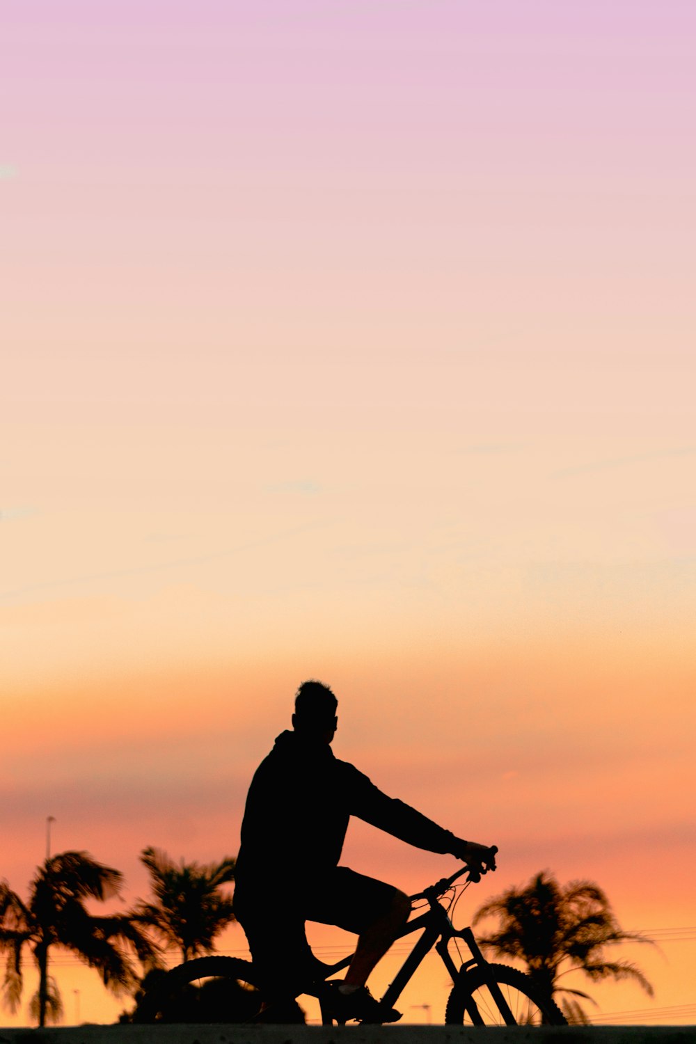 Silhouette eines Mannes, der bei Sonnenuntergang auf dem Boden steht