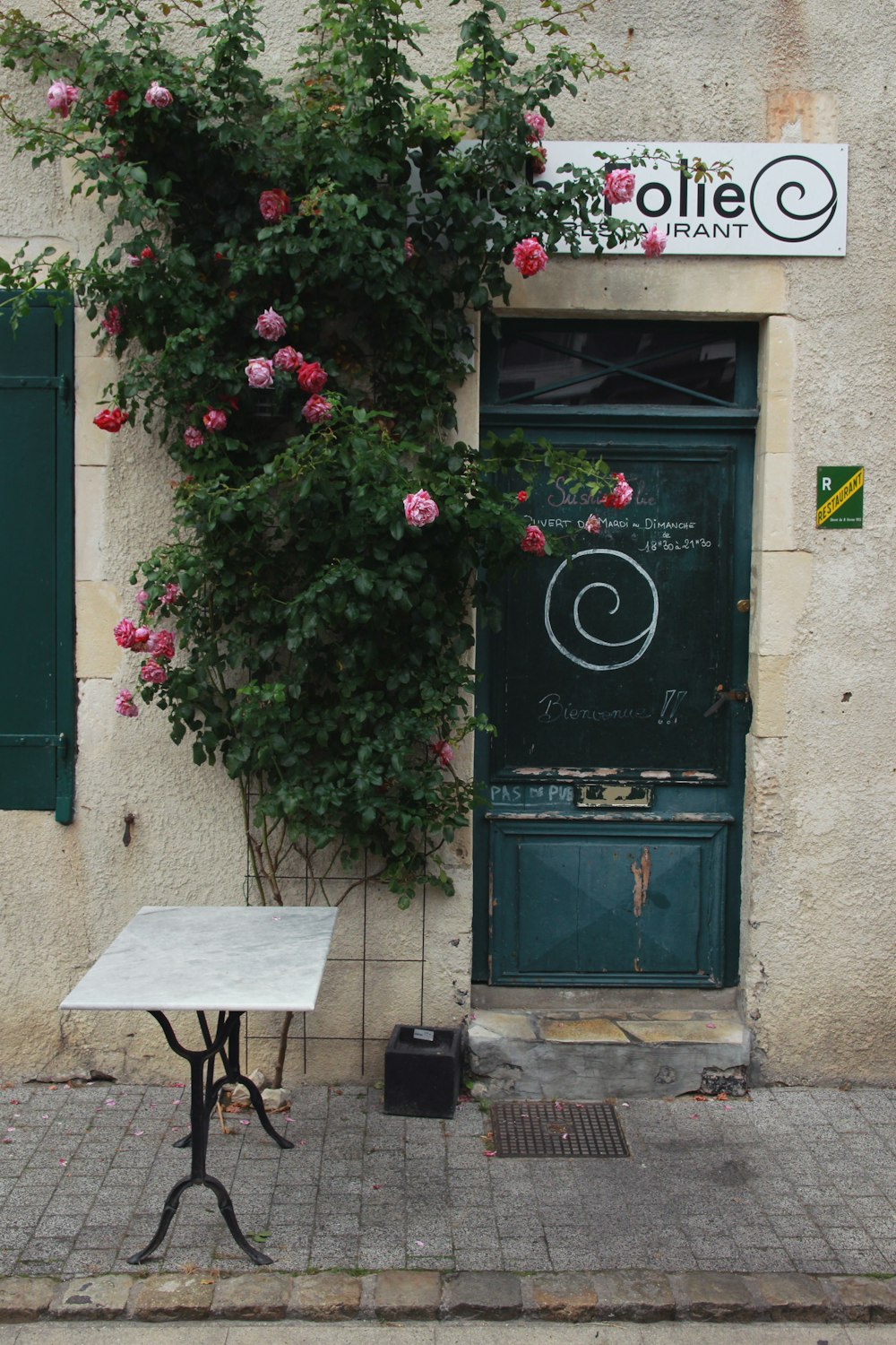 green wooden door with red and white flowers