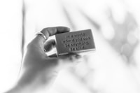 grayscale photo of person holding quote board