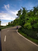 A scenic view of a scooter on a winding road.