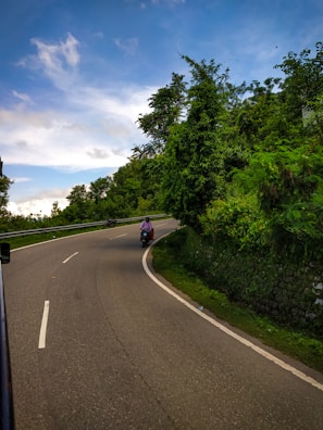 A scenic view of a scooter on a winding road.
