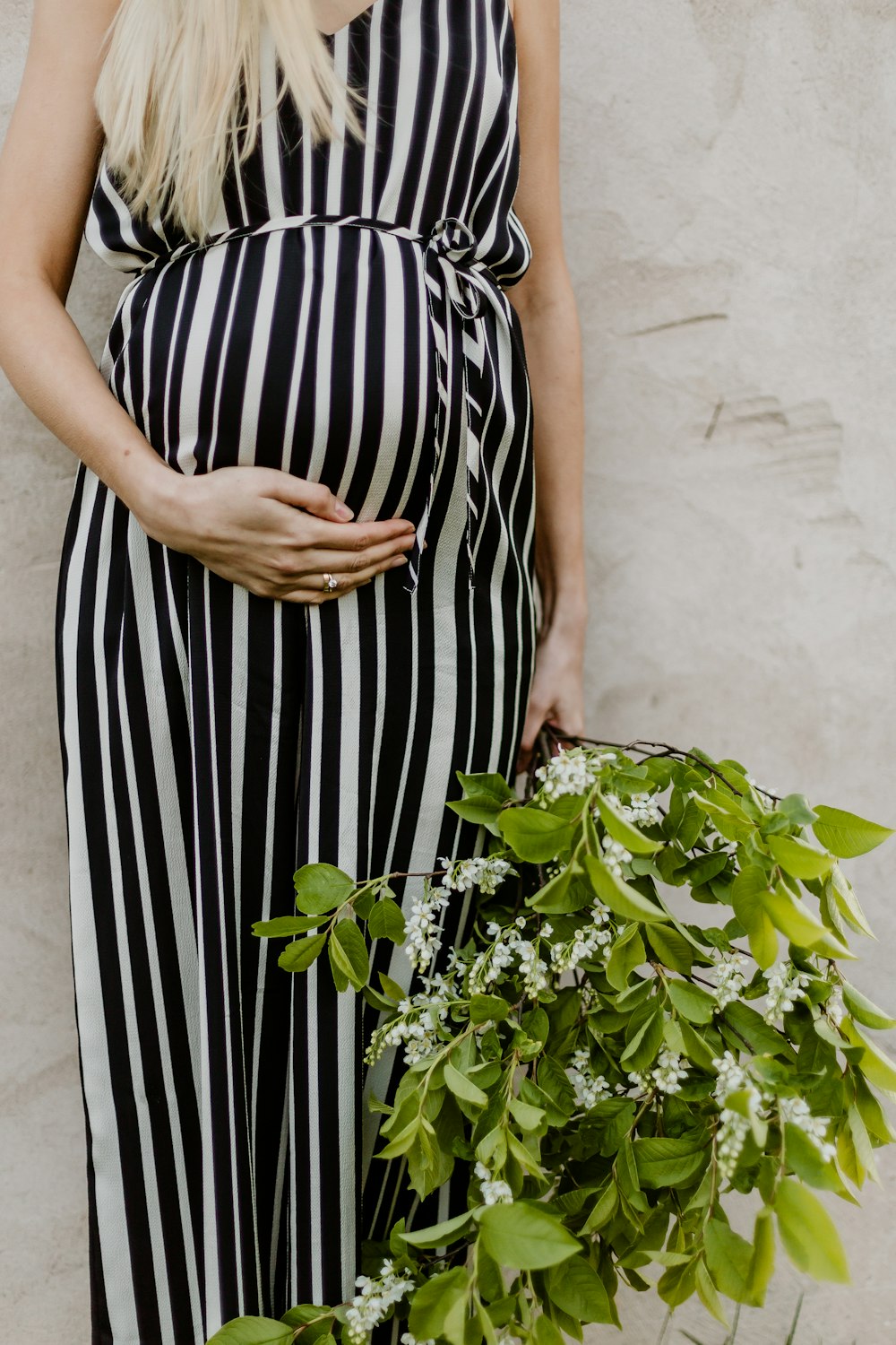 woman in black and white stripe dress holding green plant