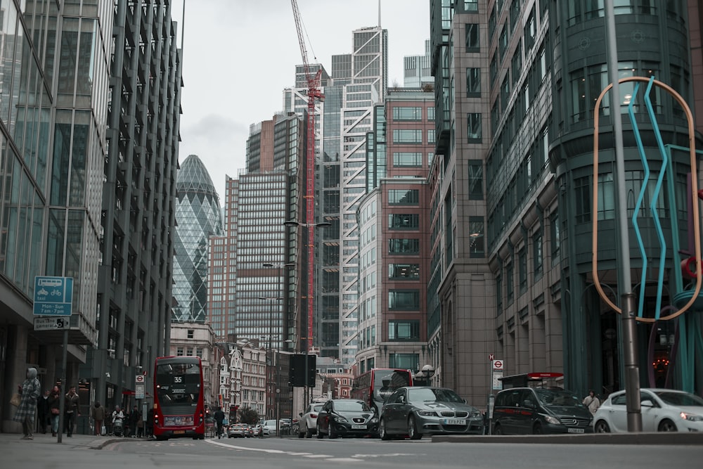 cars parked on the side of the road in front of high rise buildings during daytime