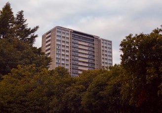 green trees near white concrete building during daytime