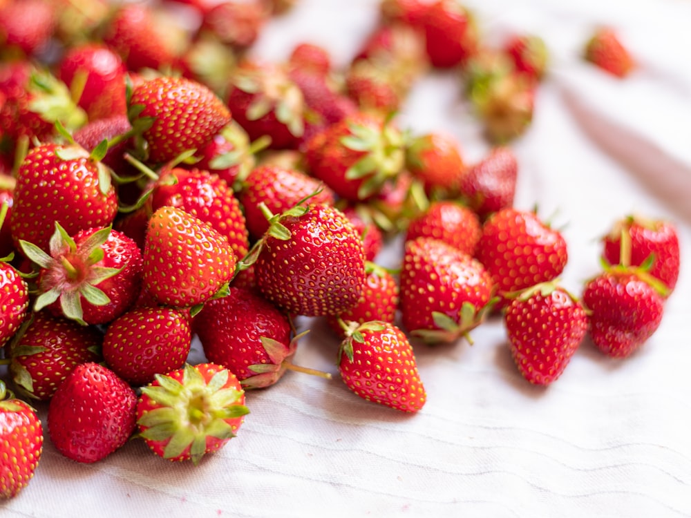 strawberries on white textile during daytime