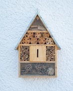 brown wooden bird house on white wall
