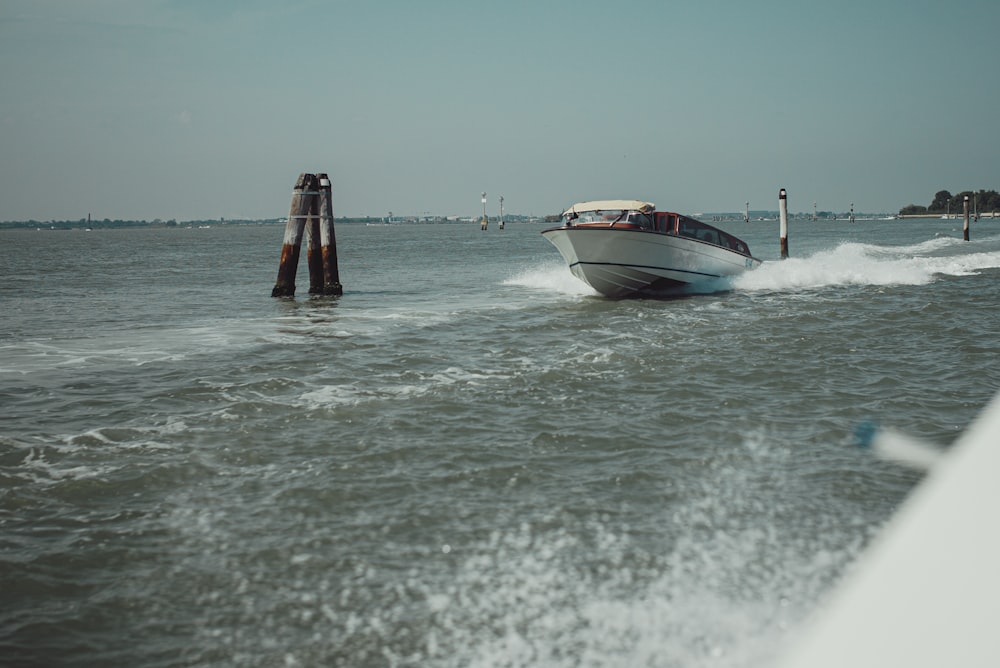 weißes und blaues Boot tagsüber auf See