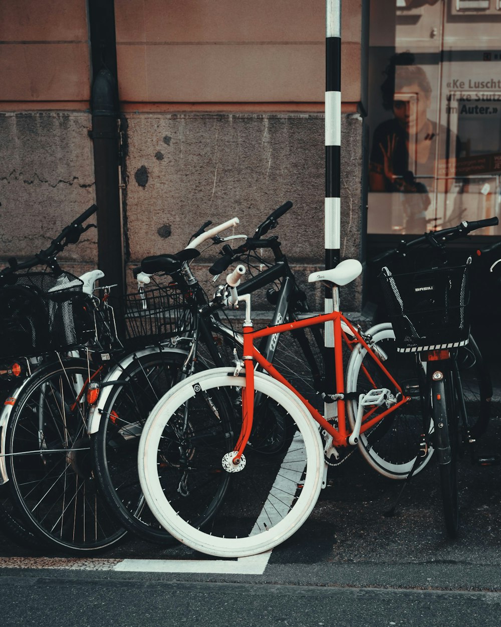 red and black city bikes parked beside black metal fence