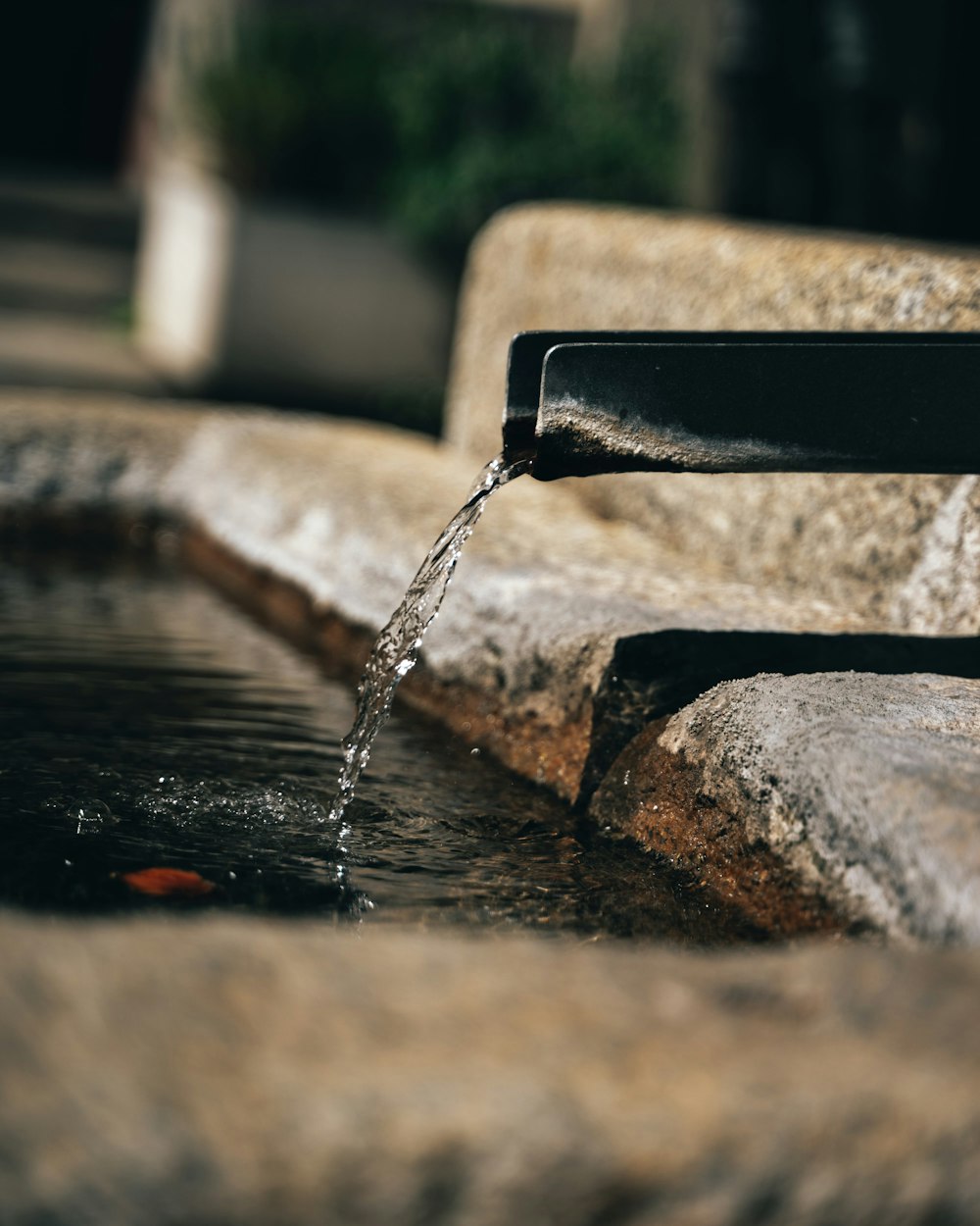 water falling from black metal bench