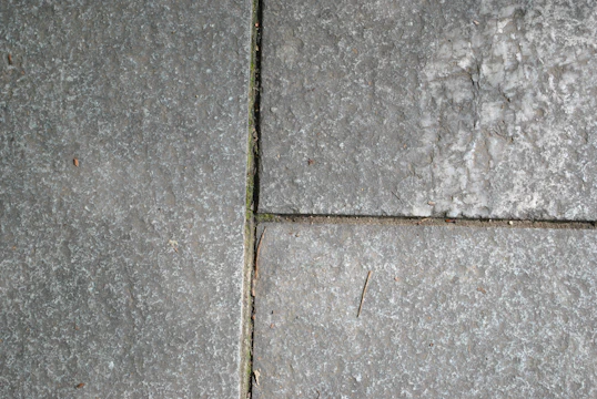 A close-up of a weathered footpath with faint cosmic symbols etched into the pavement.