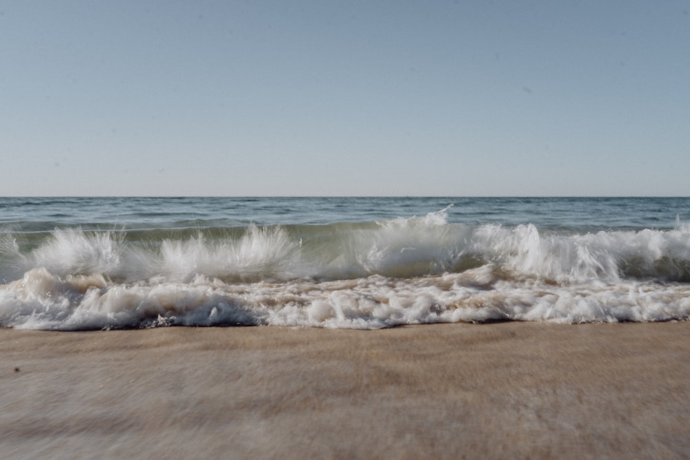 ocean waves crashing on shore during daytime