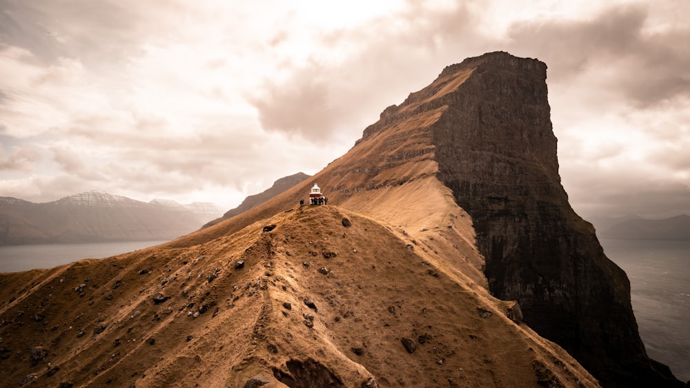 person in black jacket standing on brown rock formation during daytime