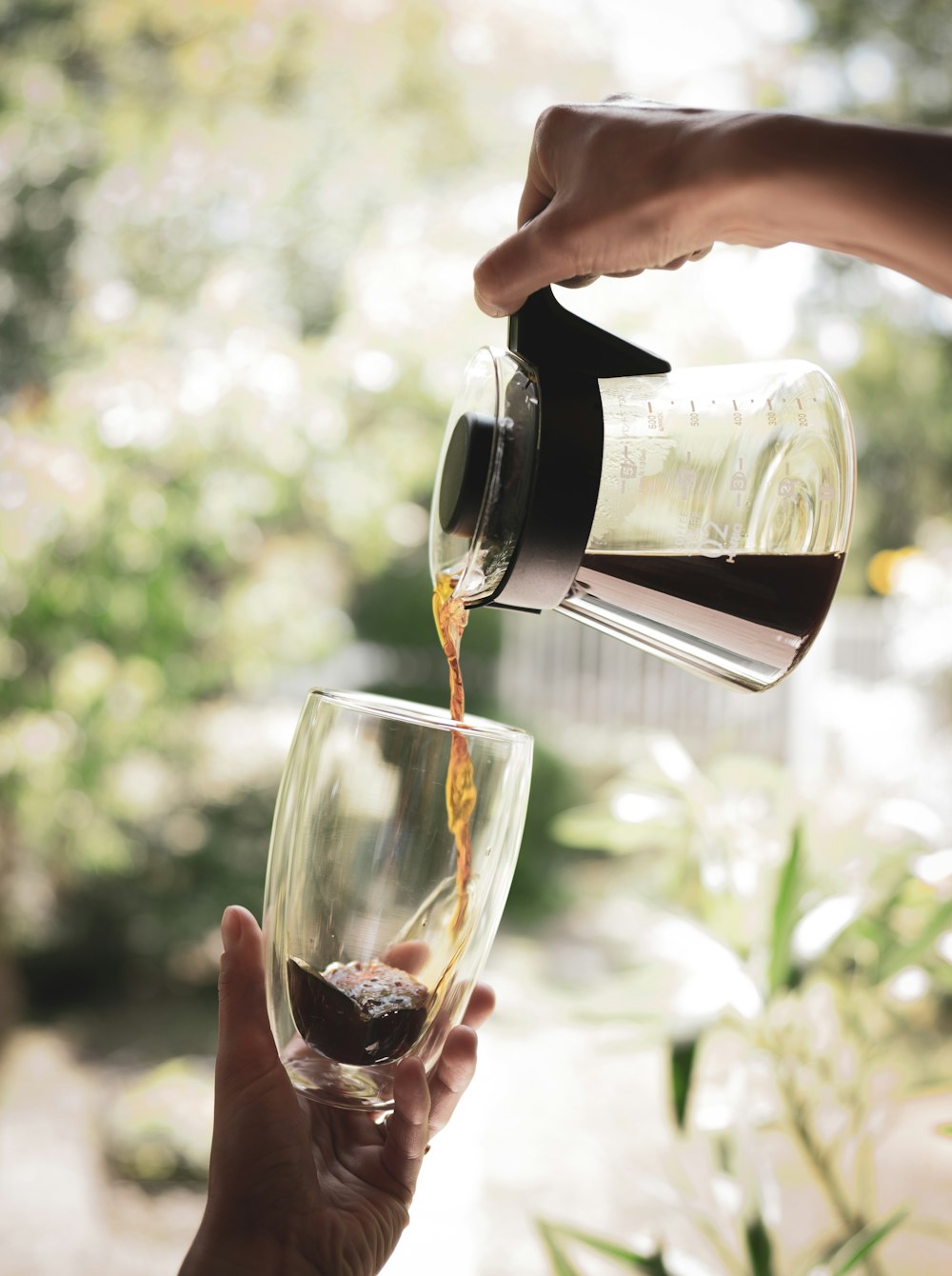 person pouring wine on clear drinking glass