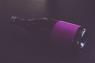 purple and black bottle on black table