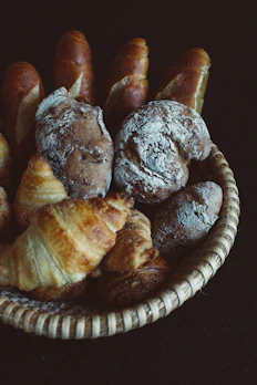 Artisan bakery display featuring golden croissants and rustic bread loaves on a wooden board.
