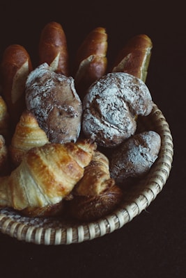 A variety of artisan breads with crusty exteriors displayed in a basket.