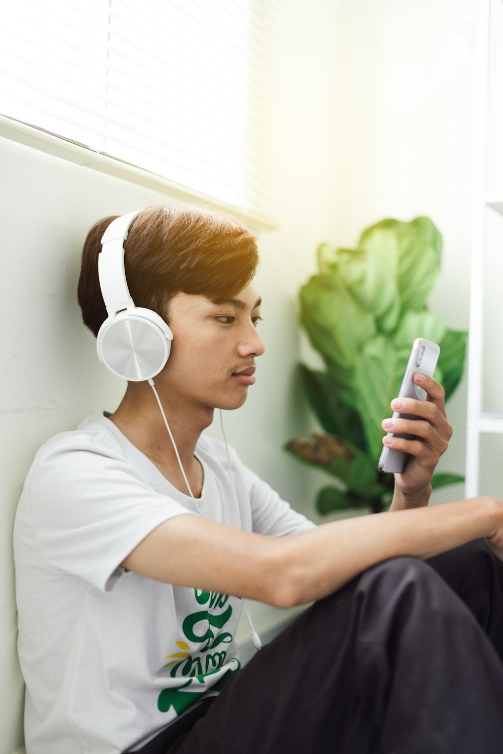 woman in white crew neck t-shirt using white earbuds