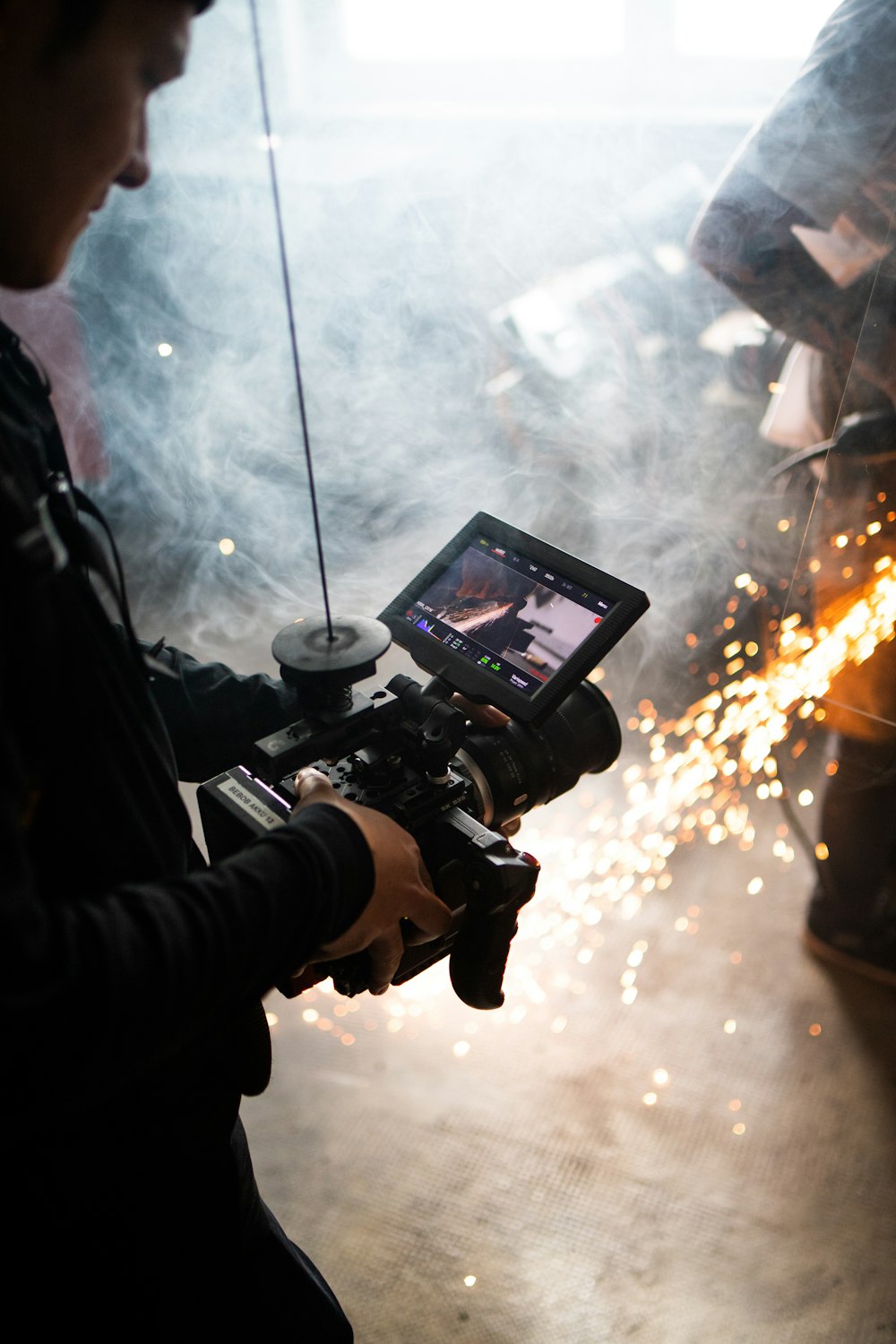 man in black jacket holding black dslr camera