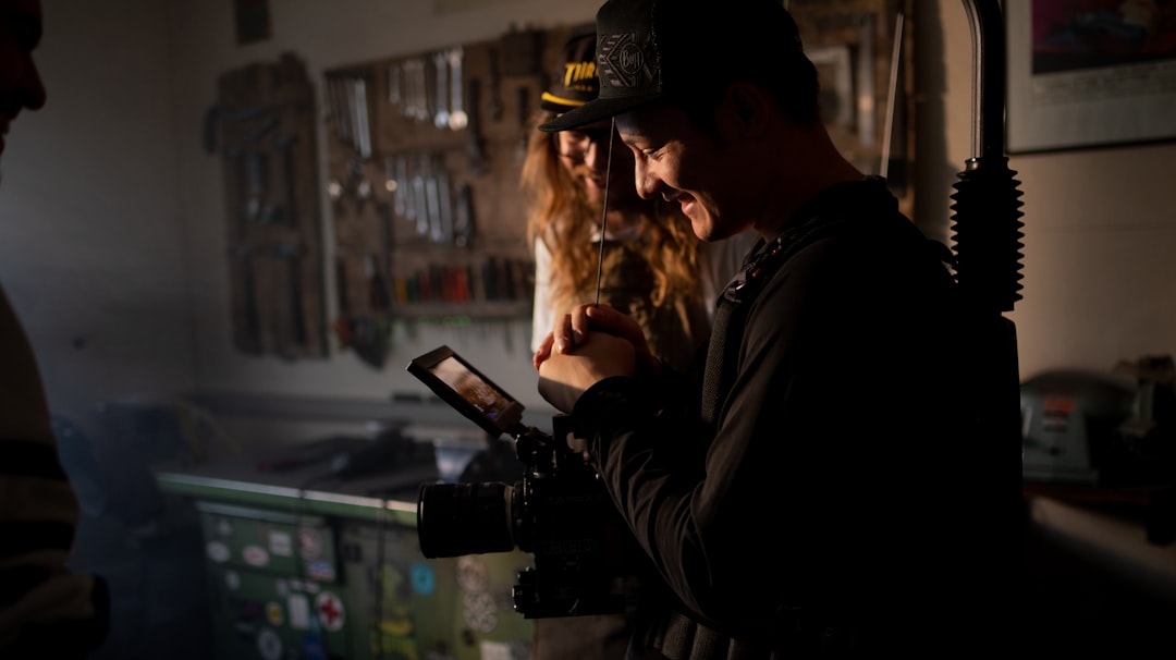 man in black jacket holding black dslr camera