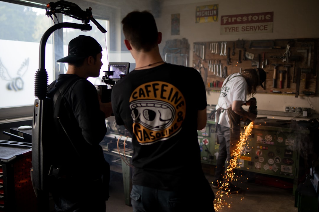 man in black and white crew neck t-shirt standing beside man in white t-shirt