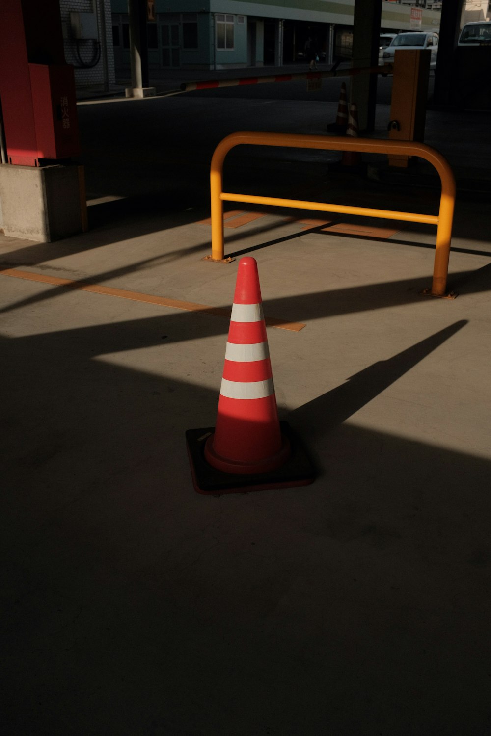 orange and white traffic cone on gray concrete floor