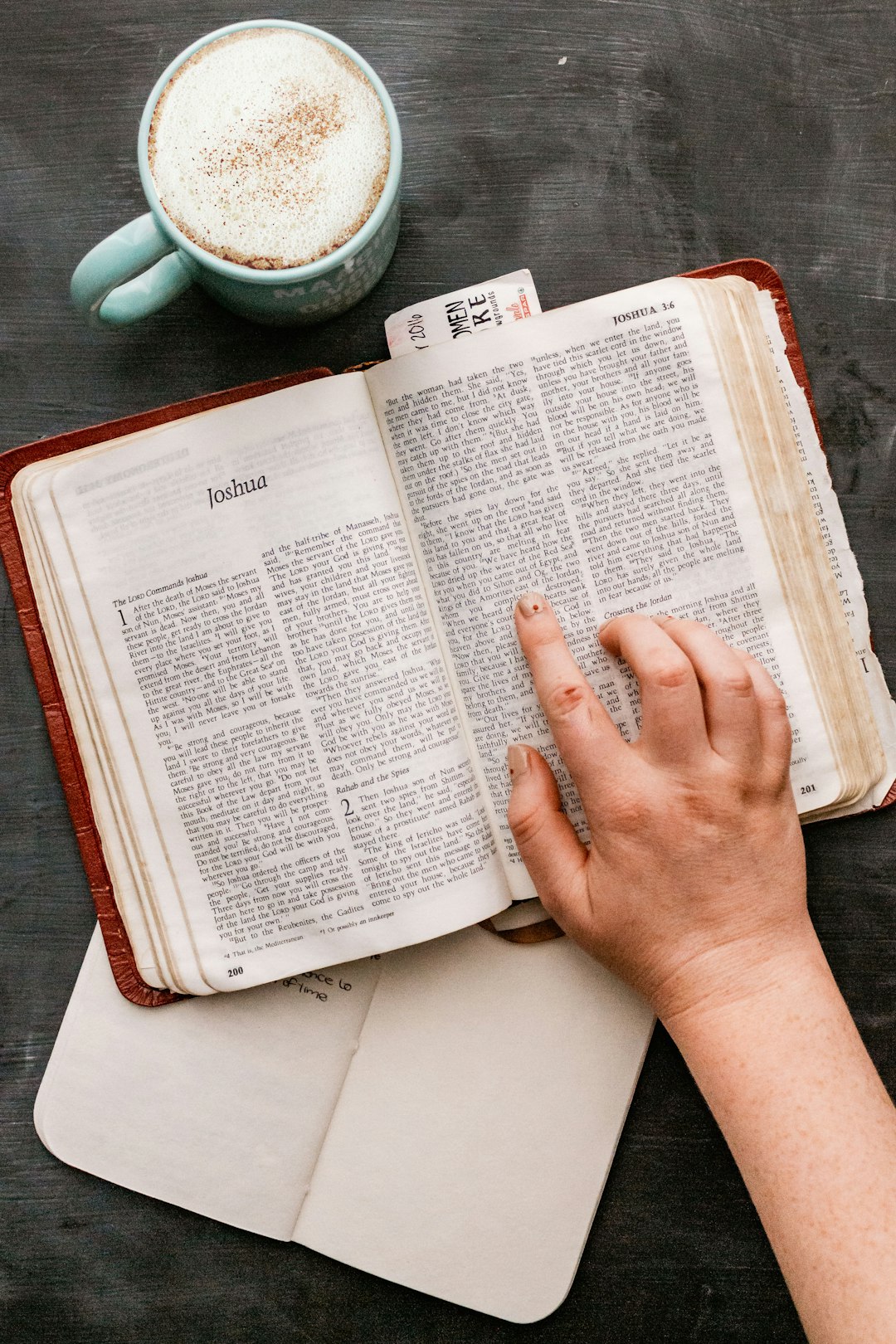 person holding book on table