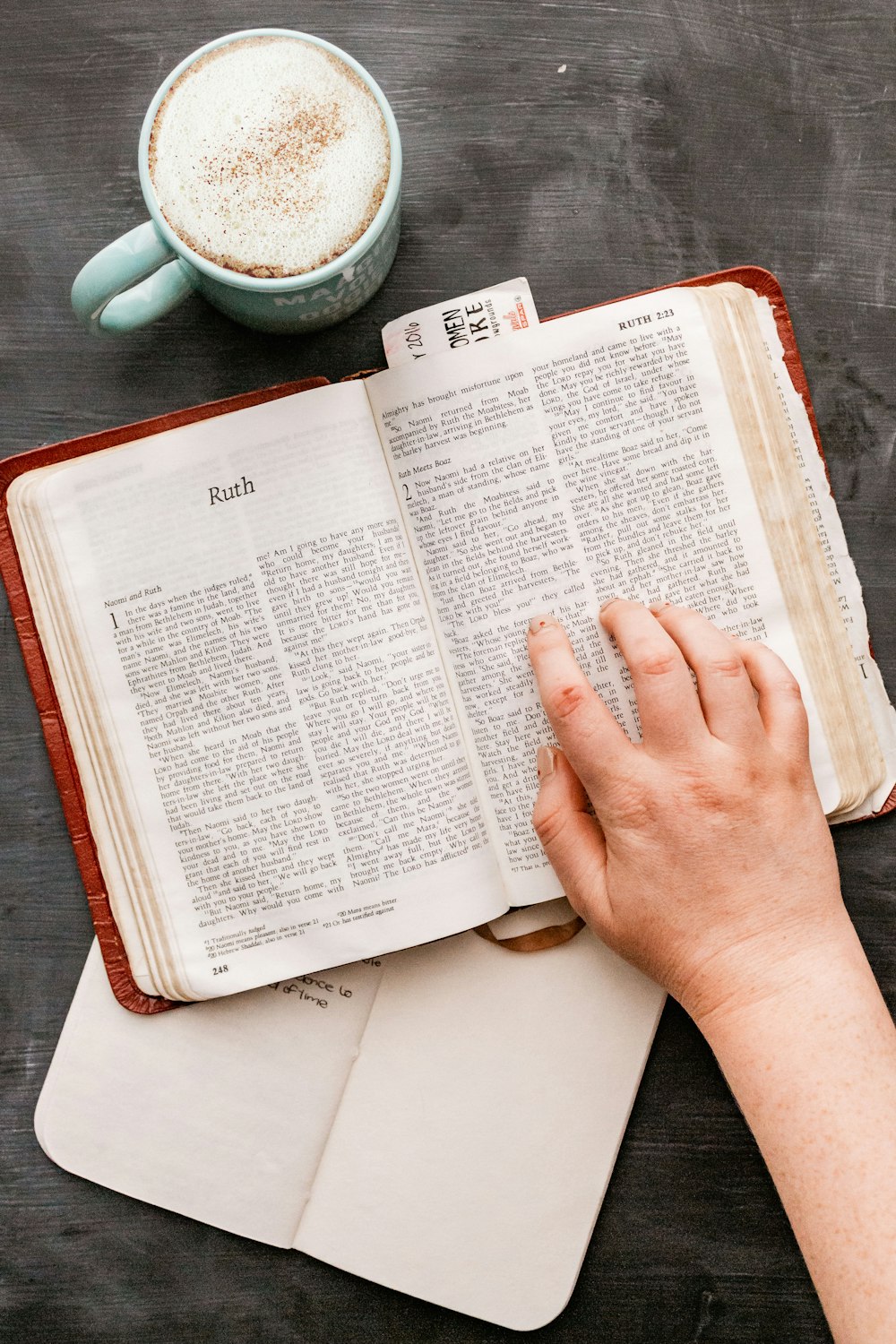 person holding book page on table