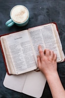 An open book with a cup of coffee beside it.