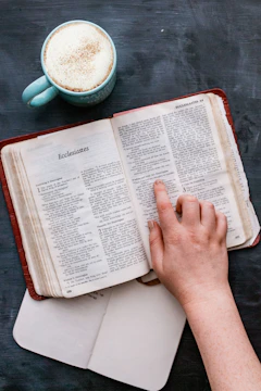 An open book with AI diagrams and a cup of coffee on a wooden desk.