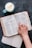 An open book with a cup of tea beside it on a wooden table.