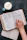 Close-up of hands flipping through the Infinite Zoe paperback devotional with a cup of tea nearby.