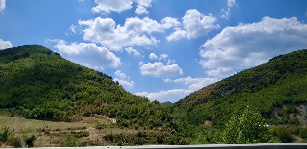 montañas verdes bajo el cielo azul y nubes blancas durante el día