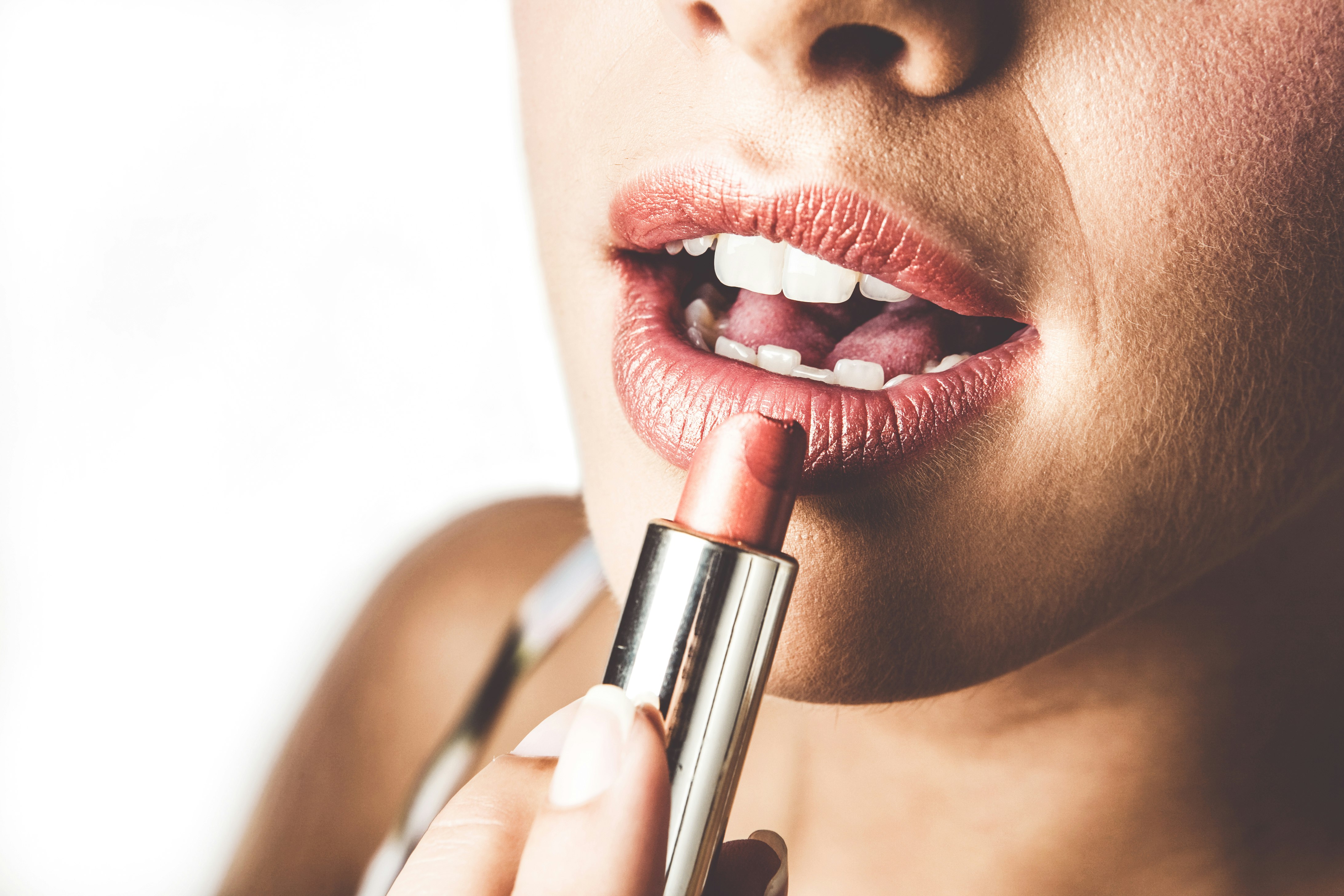 woman with red lipstick holding lipstick