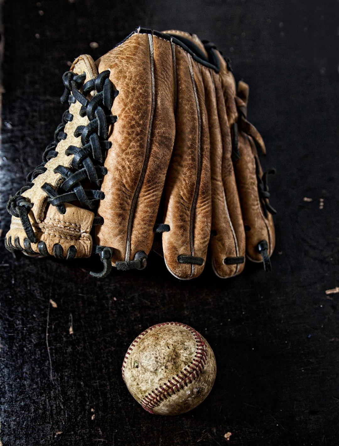 brown baseball mitt on black textile