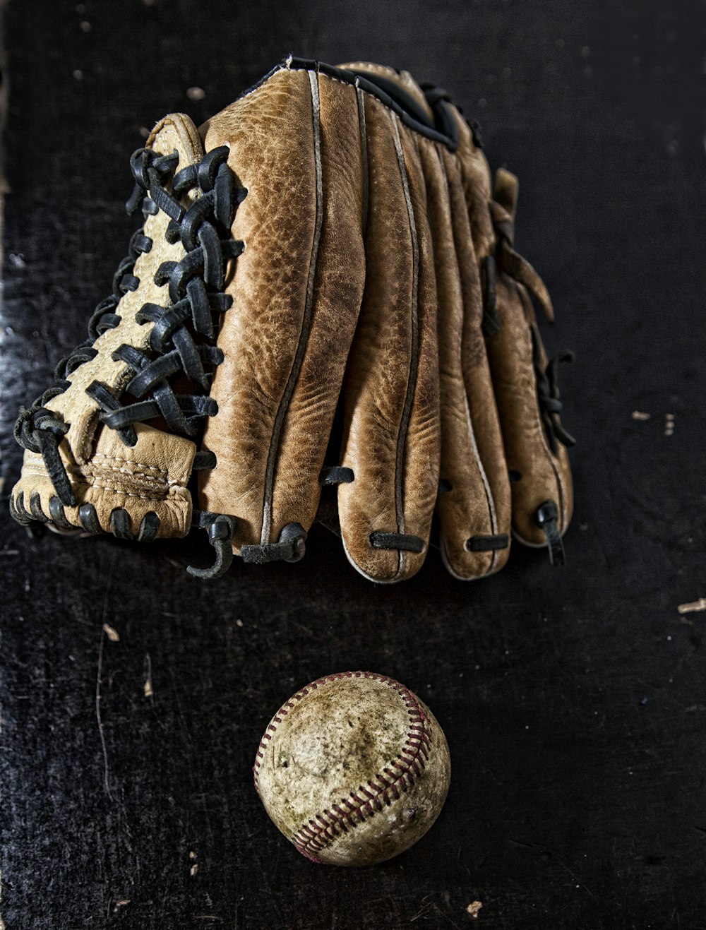 brown baseball mitt on black textile