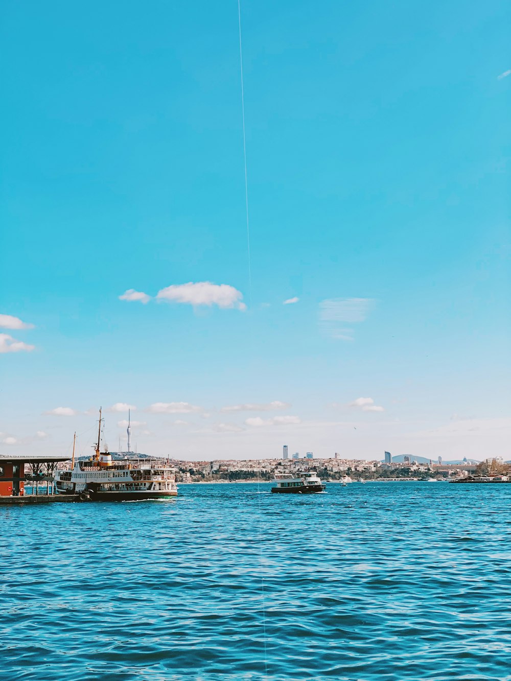 white and brown boat on sea under blue sky during daytime