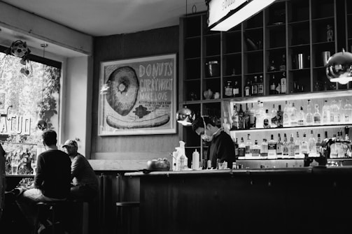 grayscale photo of man and woman sitting on chair